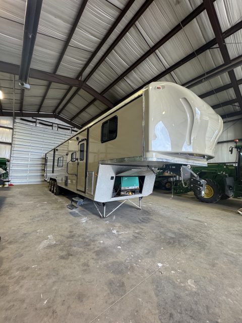 Fifth wheel with freshly restored gelcoat parked inside an Oklahoma City shop after a multi-stage polish